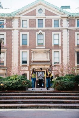students walking out a college dorm building