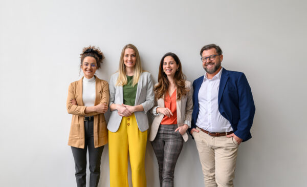 four staffing candidates standing in front of a wall